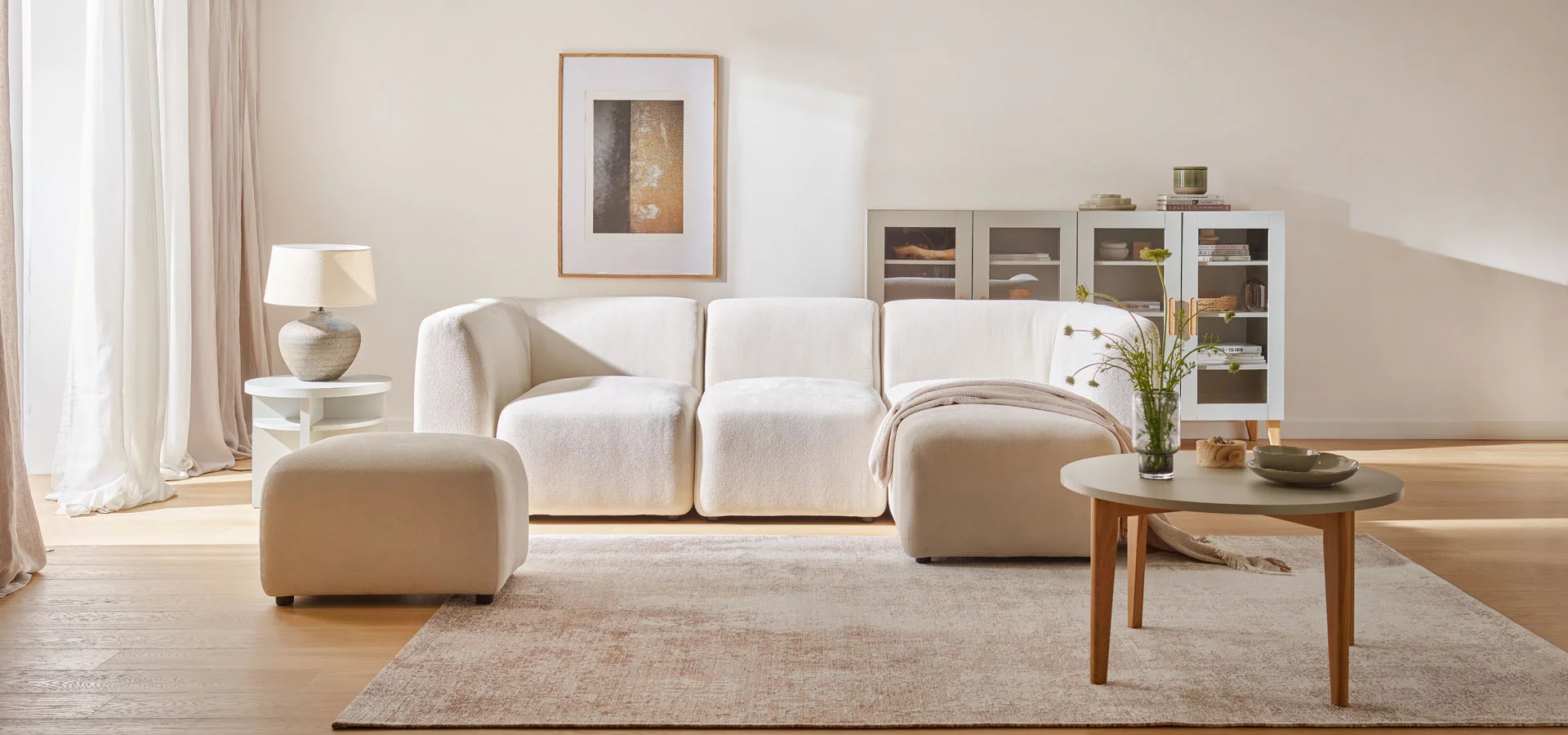 Minimalistyczny salon z beżową kanapą i delikatnym dywanem z naturalnych włókien